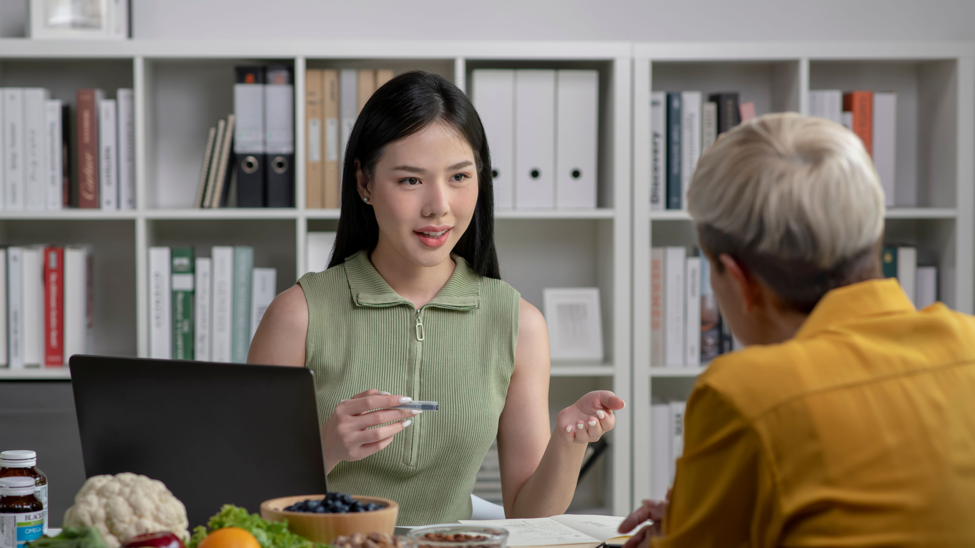 Nutritionist with woman client talking about meal plan and healthy products 